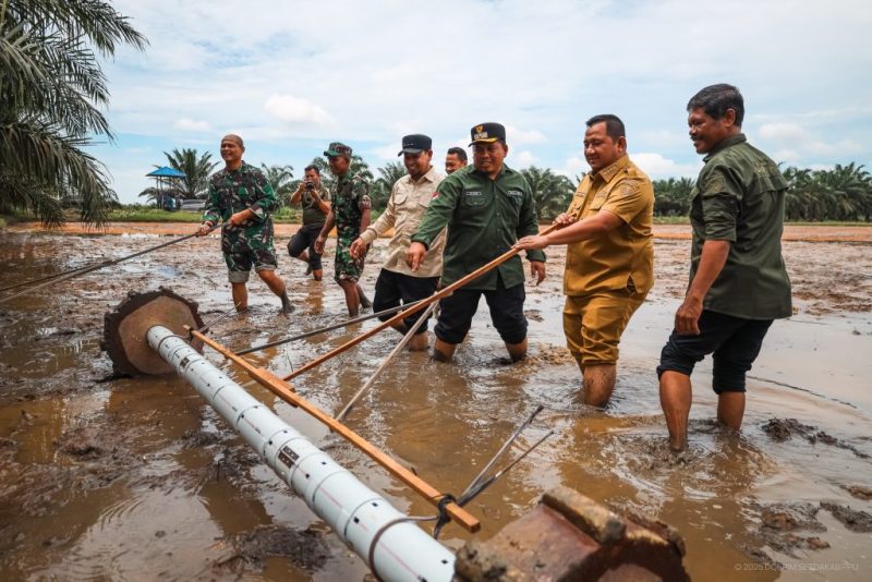 Foto: Bupati PPU Mudyat Noor saat menabur benih padi menggunakan alat tanam dalam kegiatan tanam serentak.