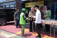 Foto : Yudhistira Yudha Permana, Kepala Kantor Imigrasi Kelas I TPI Samarinda, bersama para Karyawan membagikan makanan siap saji pada masyarakat.