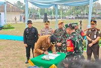 Foto: Bupati Kukar, Aulia Rahman Basri saat menandatangani berita acara usai upacara TMMD.