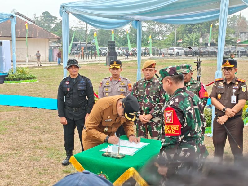 Foto: Bupati Kukar, Aulia Rahman Basri saat menandatangani berita acara usai upacara TMMD.
